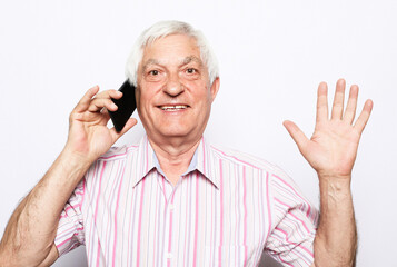 close up of happy old man using smartphone over white background.