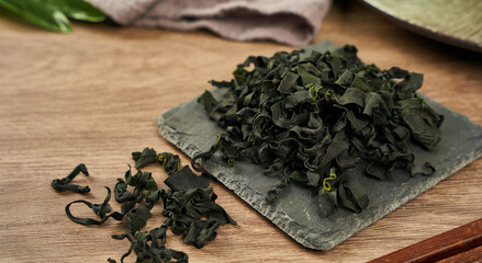 dried Laminaria (Kelp) Seaweed on ceramic plate Background. dried Laminaria or kelp Seaweed on...