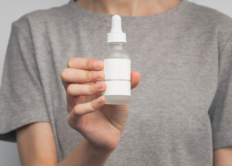 Blank white cosmetic tube isolated on white background. female hand with applied cream touches cosmetic tube. Concept of cream, hand lotion. Winter skin care. Woman using hand cream from a tube. 