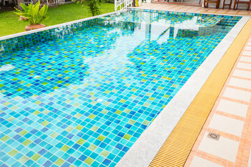 Macro from Swimming pool with clear blue water in a garden area, surrounded by plants
