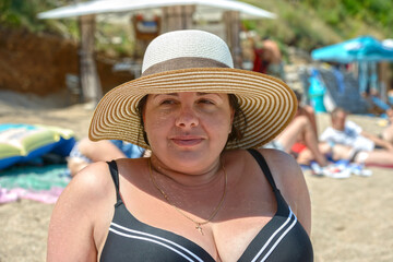 Summer portrait of young adult woman wearing straw hat.