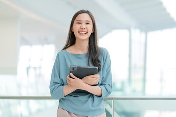 asian smiling cheerful female digital nomad hand hold tablet device look at camera portrait...