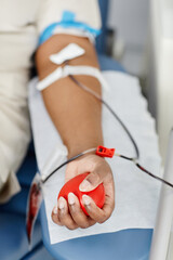 Close up of unrecognizable African American woman giving blood while laying in chair at blood...