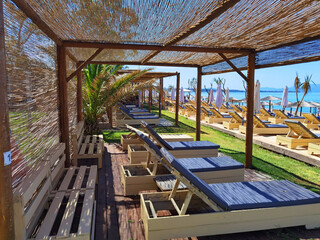 sea beach bar umbrellas and chairs by sand in preveza, monolithi beach greece