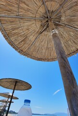 sea beach bar umbrellas and chairs by sand in preveza, monolithi beach greece