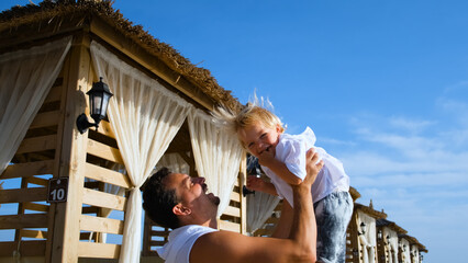 dad tosses his son up at a beach resort