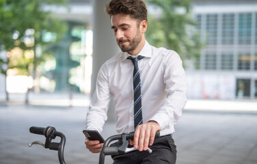 Smiling man parking his bicycle in front of the office