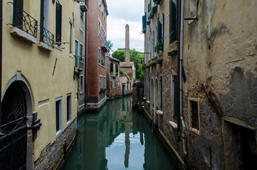 Fototapeta na wymiar La ciminiera di una fornace si riflette in un canale della Giudecca a Venezia