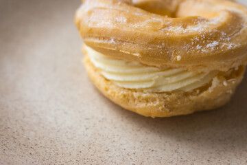 Sweet bun with cream. Fresh creamy donut on plate. Baked pastry. Sweet roll with ricotta. Delicious dessert. Homemade cuisine. Sweet food. Glazed doughnut. Bun with vanilla airy cream.