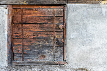 Small wooden door in the concrete base of the house