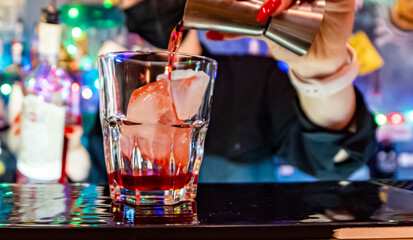 woman hand bartender making negroni cocktail in bar