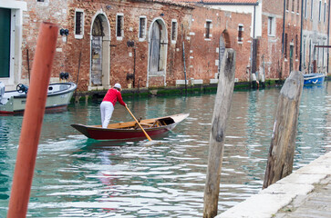Un uomo voga alla veneziana in un canale del sestiere di Cannaregio