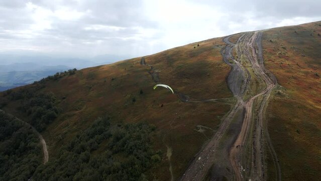 following after paraglider flying above ukrainian carpathian mountains
