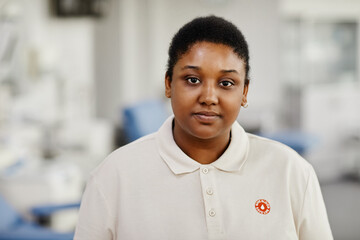 Portrait of black young woman standing in blood donation center with Save life sticker on chest and...