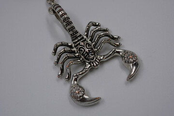 Large silver, metallic, militant figure of a scorpion located on a white background.  Zodiac sign...