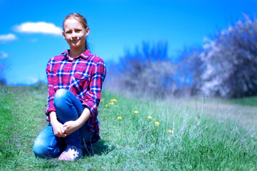 Naklejka na ściany i meble Girl in a plaid shirt in nature. Travel