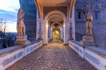 Vew of the covered bridge with statues in Cesky Krumlov castle in the sunrise. Czech Republic.