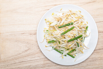 Healthy vegetarian food fried bean sprout in plate on wood table.