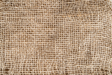 Brown beige background with structure texture of rough canvas burlap fabric close-up.