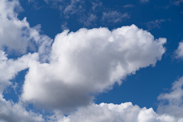 White fluffy cumulus clouds on a blue sky close-up.