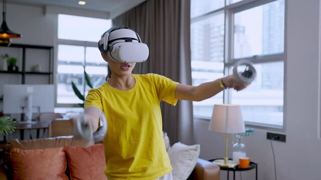 casual technology lifestyle at home,asian adult female Woman playing VR game metaverse digital world technology AR augmented reality control,Asian gamer woman playing virtual reality action game