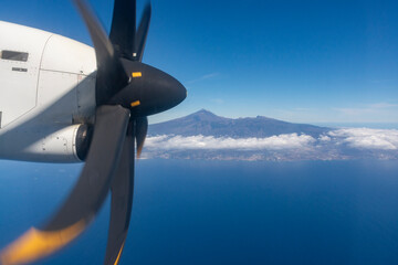 Naklejka na ściany i meble Flying propeller plane above Tenerife island with peak of Mount Teide, volcatic landscape, Canary islands, Spain