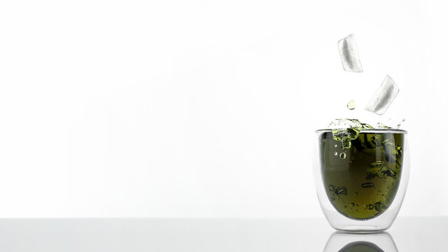 Glass of water with chlorophyll extract against white grey background. Liquid chlorophyll in a glass of water with ice splash. Concept of superfood, healthy eating, detox and diet. Banner, copy space
