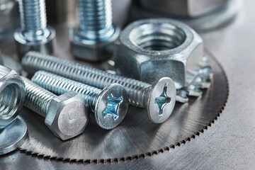 set of different nuts, bolts, screws, washers and drill bits,thread tap and mill cutters on steel plate background. Locksmithing deal.