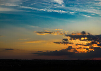 Evening sky. The rays of the sun break through the clouds above the horizon. Abstract background. Sunset.