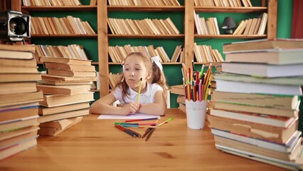 portrait of a tired young blond girl teaches lessons with a notebook at table in the school. Teen schoolgirl shows a picture with the inscription help while studying. Close-up face