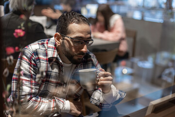 カフェで一人たそがれる中東系男性