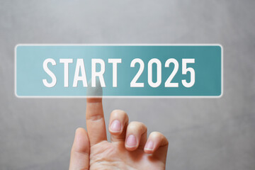 Finger pressing blue transparent start 2025 button on virtual interface on gray background with copy space for text. Concept of new year.
