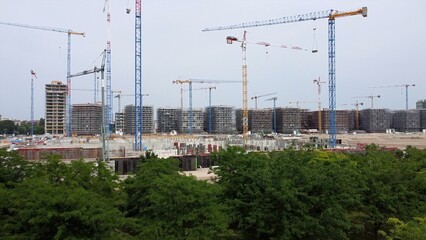 Drone view of Sei Milano, new GARDEN CITY  in the western suburbs near Bisceglie subway. Urban regeneration project and green revolution - building site and gru for the new skyline and skyscrapers 