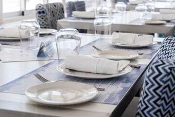 Views of the interior of an empty and closed restaurant, with the tables prepared with cutlery, crockery and glasses. 