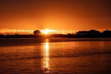 Naklejka premium sun setting over the sea with Langstone bridge in the background 