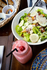 Strawberry shake, vegetable salad and bread on the table