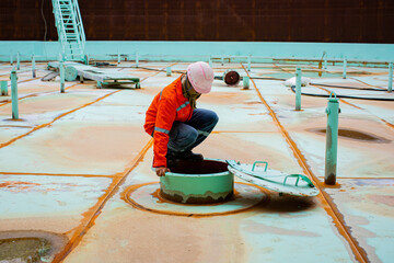 Male worker inside the pontoon tank storage visual inspection tank into the confined space - obrazy, fototapety, plakaty