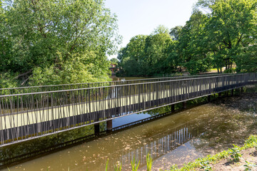 Fototapeta na wymiar New iron bridge over the pond in the park