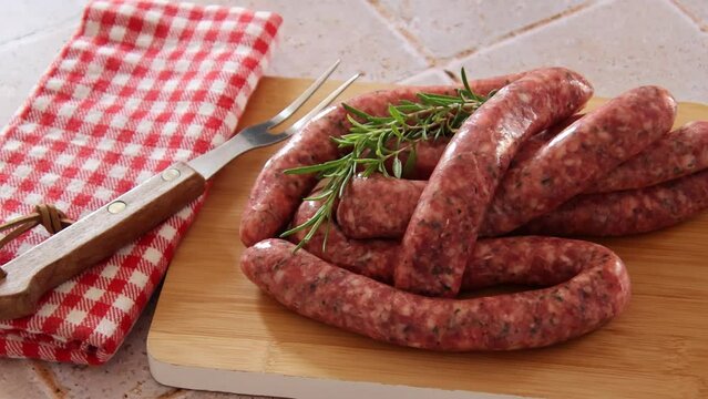 raw sausages for grilling on a wooden board