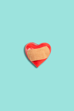 Abstract love concept. Red heart with medical healing patch on blue background