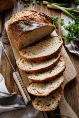 Sliced traditional sourdough bread on a wooden board, close-up view