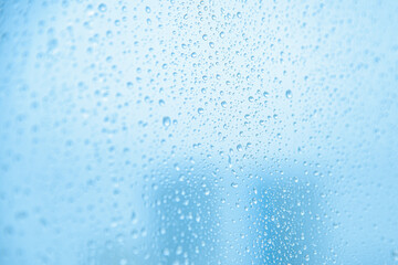 Water drops on glass, blue background.