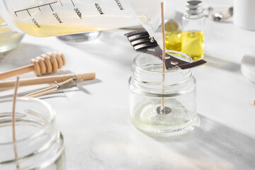 Set tools for homemade natural eco-friendly soy wax candles, wick, perfume, essential oil on a marble table. Making process. Trendy DIY. Craft hobby, small business, artisan products concept