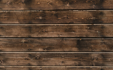 Fototapeta premium Minimalistic background and plenty of space for text. Dark brown painted and varnished wooden boards close-up. Wall of rustic frame house made of natural wood.