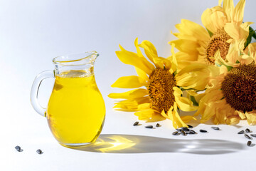 Bottle of sunflower oil and sunflower flowers with seeds on a white background