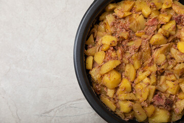 Stewed pork with potatoes and onions on a gray background.Copy space. Place for text. Recipe for fried potatoes.