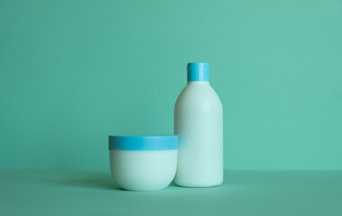 A bottle for cosmetic products and a jar of cream without a label. Facial skin care concept