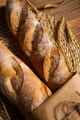 French baguette, long loaf with
wheat ears on the wooden table