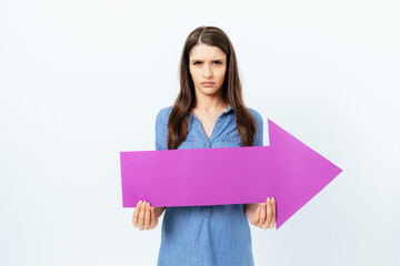 Angry displeased young woman holding big arrow pointing