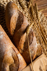 French baguette, long loaf with
wheat ears on the wooden table